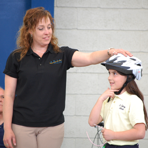 Child gets her helmet fitted at Bike to School Day event